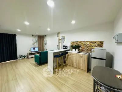 Modern open-layout living room with stylish kitchen and cozy seating area