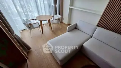 Modern living room with sleek furniture and large windows offering natural light.