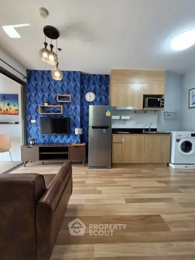 Modern living room with open kitchen, featuring stylish decor and appliances, perfect for urban living.