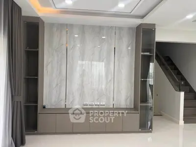 Modern living room with elegant built-in shelving and marble accent wall