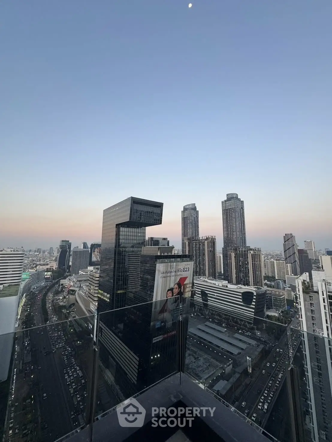 Stunning cityscape view from a high-rise balcony at sunset, showcasing modern skyscrapers and urban skyline.