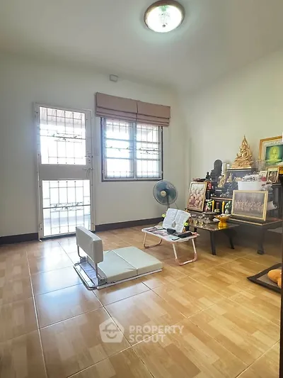 Cozy living room with natural light, minimalist decor, and tiled flooring, perfect for relaxation and meditation.