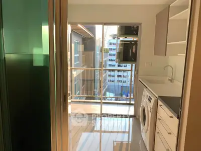 Modern kitchen with balcony view and washing machine in urban apartment
