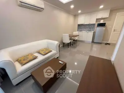 Modern living room with sleek furniture and open kitchen layout in a stylish apartment.