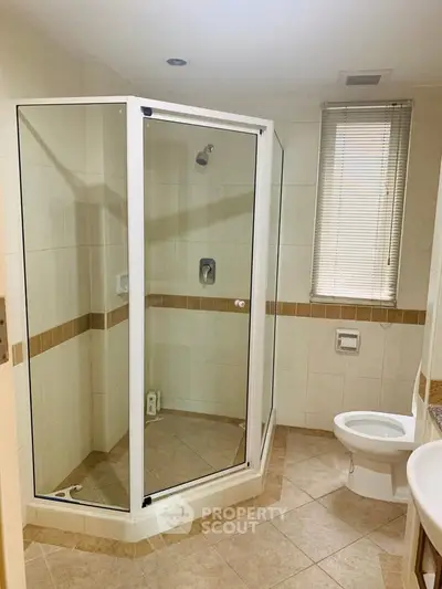 Modern bathroom with glass shower and neutral tiles