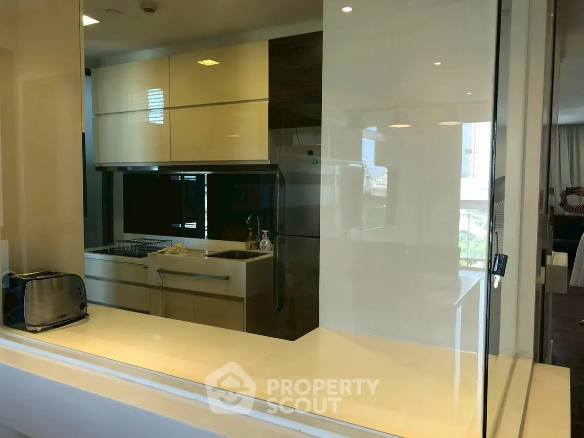 Modern kitchen with sleek cabinetry and stainless steel appliances in a stylish apartment.
