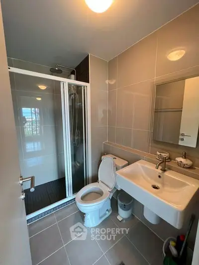 Modern bathroom with sleek shower and contemporary fixtures in a stylish apartment.