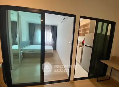 Modern apartment with sliding glass doors, bedroom and kitchen view