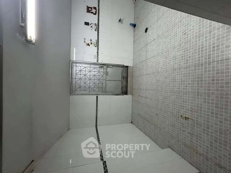 Spacious tiled bathroom with modern fixtures and ample lighting