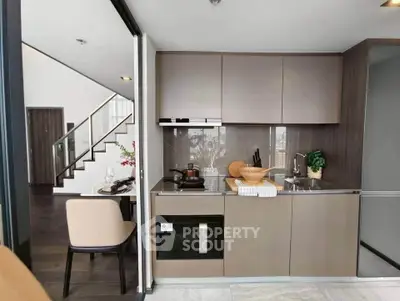 Modern kitchen with sleek cabinetry and integrated appliances in a stylish open-plan apartment.