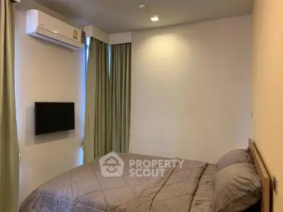 Cozy bedroom with modern air conditioning and wall-mounted TV, perfect for relaxation.
