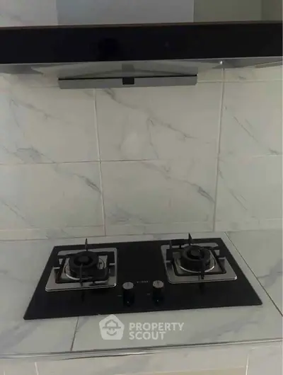 Modern kitchen with sleek gas stove and marble backsplash