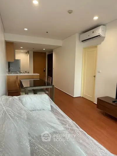 Modern living room with open kitchen layout and air conditioning in a cozy apartment.