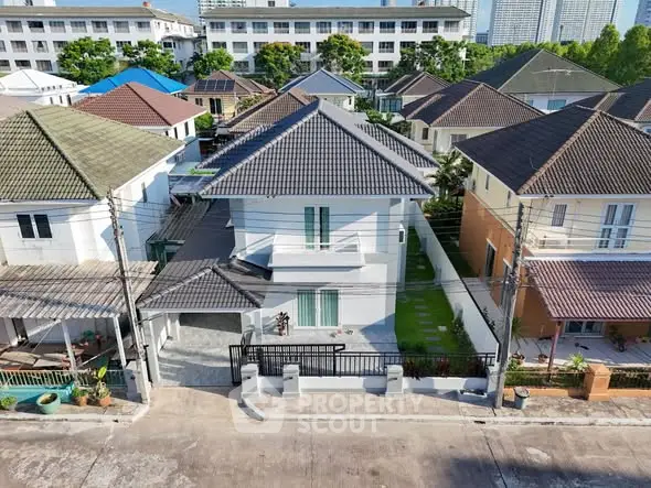 Aerial view of modern suburban homes with tiled roofs and landscaped gardens in a peaceful neighborhood.
