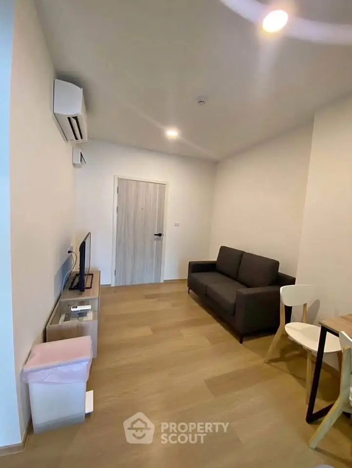 Modern living room with sleek furniture and wooden flooring, perfect for cozy gatherings.