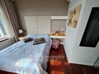 Cozy bedroom with elegant decor and hardwood floors, featuring a comfortable bed and stylish wall art.