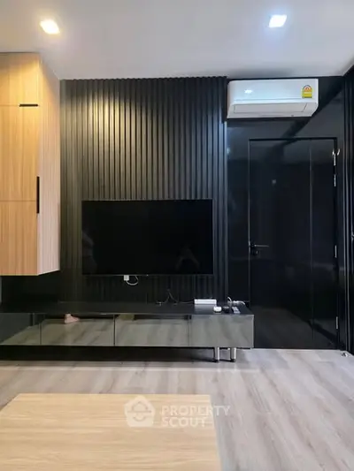 Modern living room with sleek black paneling, wall-mounted TV, and air conditioning unit.
