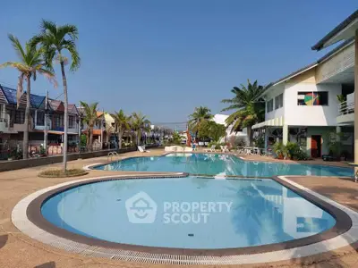 Stunning residential complex with a large swimming pool and tropical landscaping.