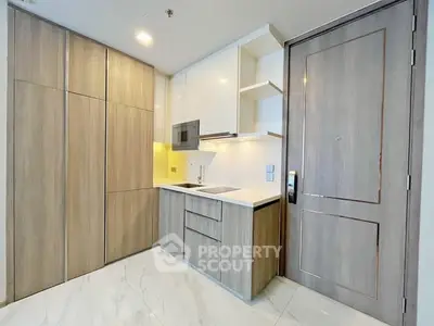 Modern compact kitchen with sleek cabinetry and integrated appliances in a stylish apartment.