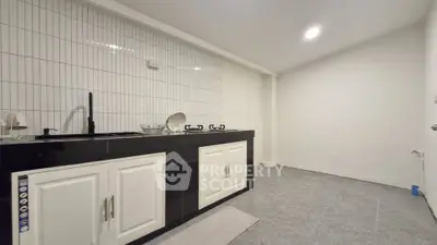 Modern minimalist kitchen with sleek black countertops and white cabinetry