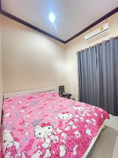 Cozy bedroom with playful Hello Kitty bedding and modern air conditioning.