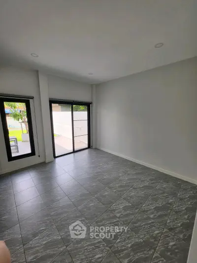 Spacious unfurnished room with large windows and tiled floor, perfect for customization.