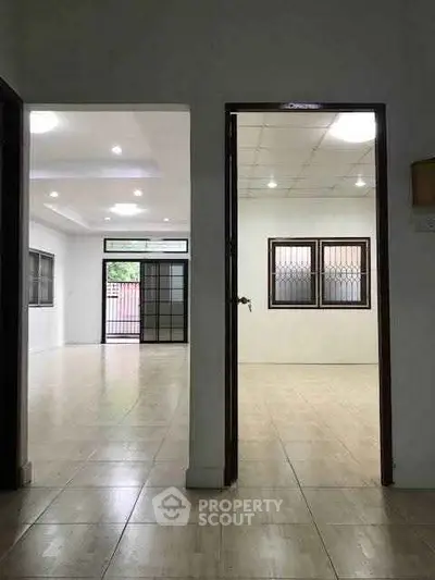 Spacious interior with tiled floors and large windows, ideal for modern living.