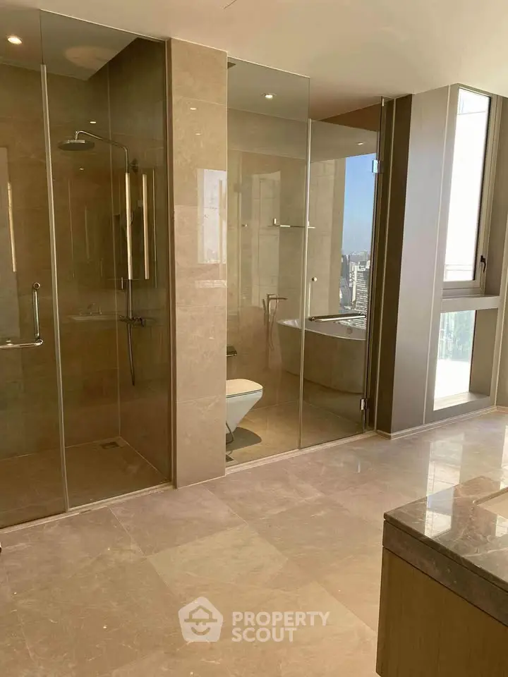 Luxurious bathroom with glass shower and city view, featuring elegant marble flooring.