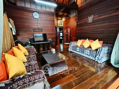 Charming wooden living room with cozy sofas and vibrant cushions, perfect for relaxation.