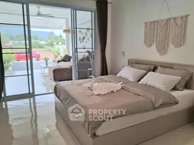 Spacious bedroom with elegant decor and view of outdoor patio, perfect for relaxation.