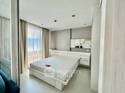 Spacious bedroom with modern design, ample natural light, and integrated living space, featuring a large bed and sleek furnishings.