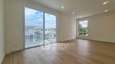 Spacious living room with large windows and balcony access in modern home