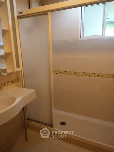 Modern bathroom with frosted glass shower door and stylish tile accents.