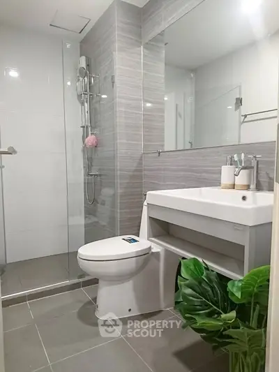 Modern bathroom with sleek design, featuring a spacious shower and elegant fixtures.
