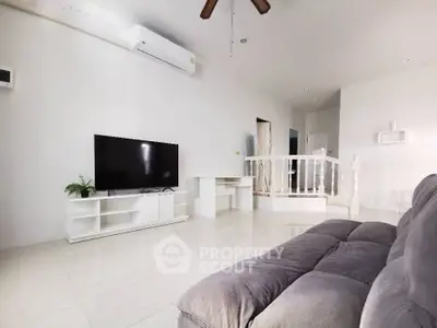 Spacious living room with modern decor and sleek TV setup