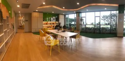 Spacious modern living area with bright yellow chairs and large windows offering garden views.
