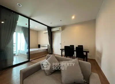 Modern apartment with open living and bedroom space, featuring stylish furniture and natural light.