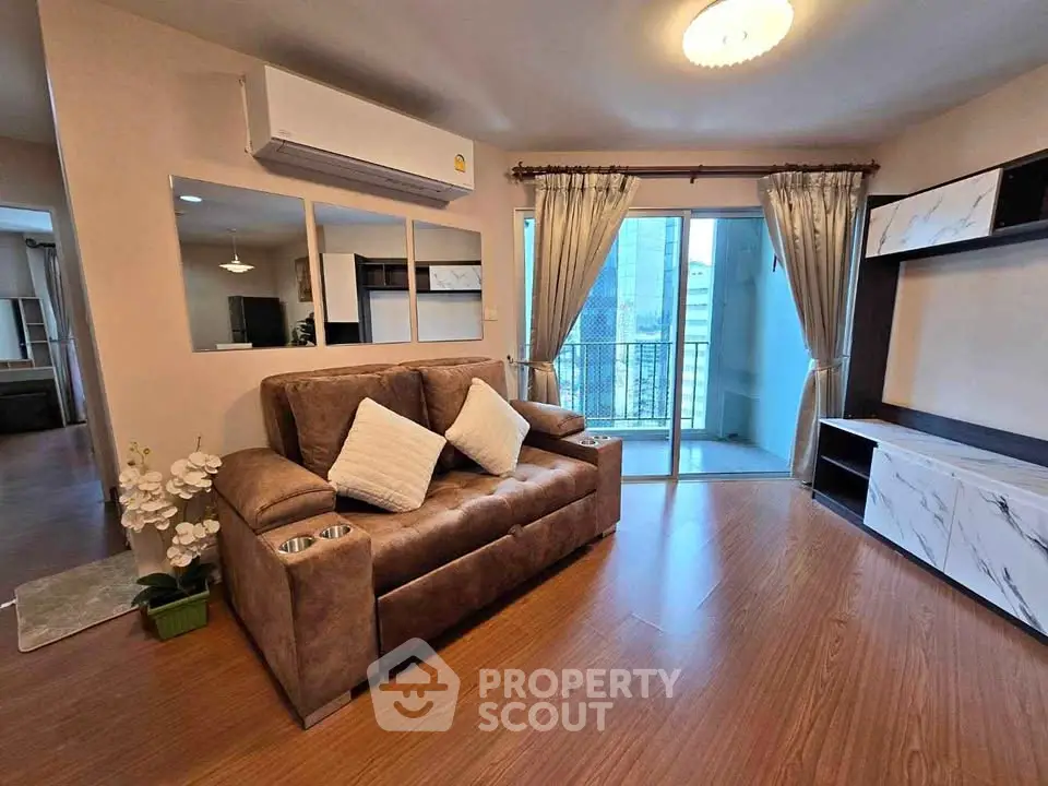 Modern living room with brown leather sofa and balcony view in a stylish apartment.