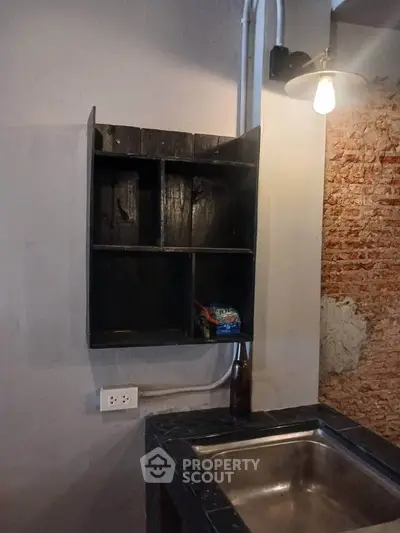Rustic kitchen corner with exposed brick and wooden shelves