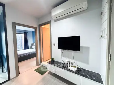 Modern apartment interior with sleek design featuring a wall-mounted TV and air conditioning unit.