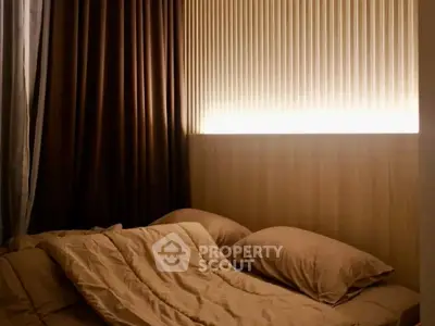 Cozy bedroom with warm lighting and elegant curtains, perfect for relaxation.