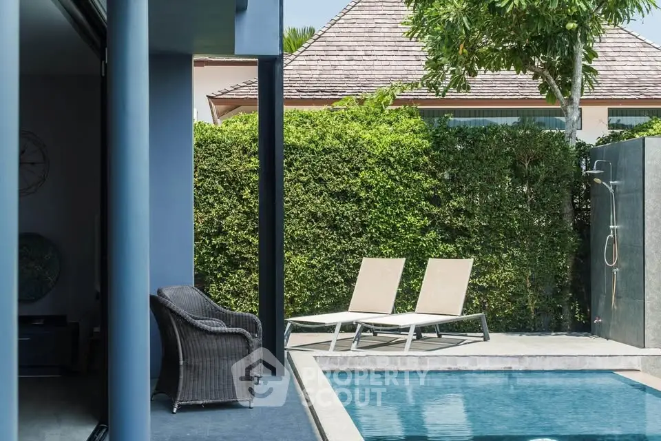 Luxurious poolside area with modern loungers and lush greenery, perfect for relaxation and outdoor enjoyment.