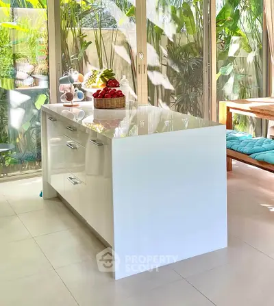 Bright modern kitchen with sleek island and garden view, perfect for culinary enthusiasts.
