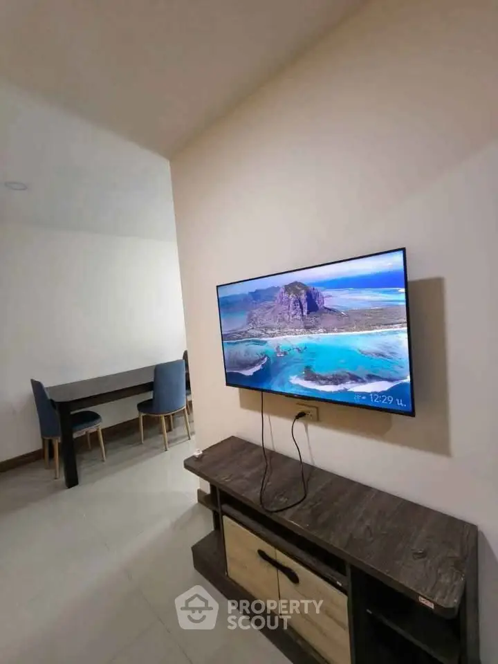 Modern living room with wall-mounted TV and stylish furniture, perfect for relaxation and entertainment.