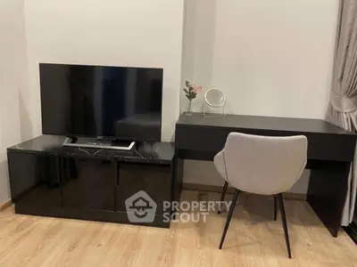 Modern living room with sleek black TV stand and stylish desk with chair, perfect for work and relaxation.