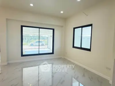 Spacious modern living room with large windows and marble flooring