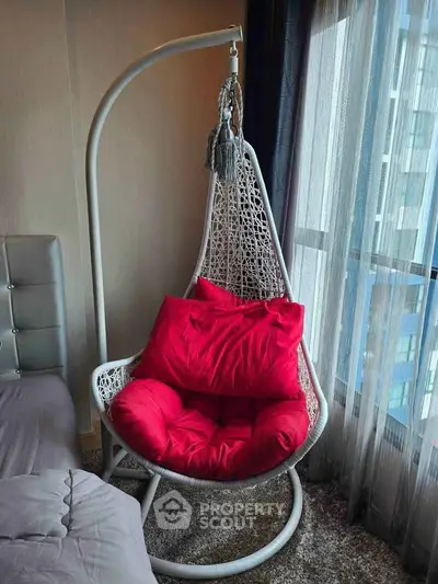 Cozy bedroom with stylish hanging chair and large window view