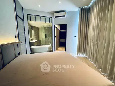 Luxurious bedroom with ensuite bathroom featuring a modern freestanding bathtub and elegant lighting.