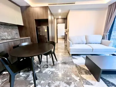 Modern living room with sleek kitchen and stylish furniture in open layout apartment.