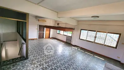 Spacious open-plan living area with large windows and tiled flooring